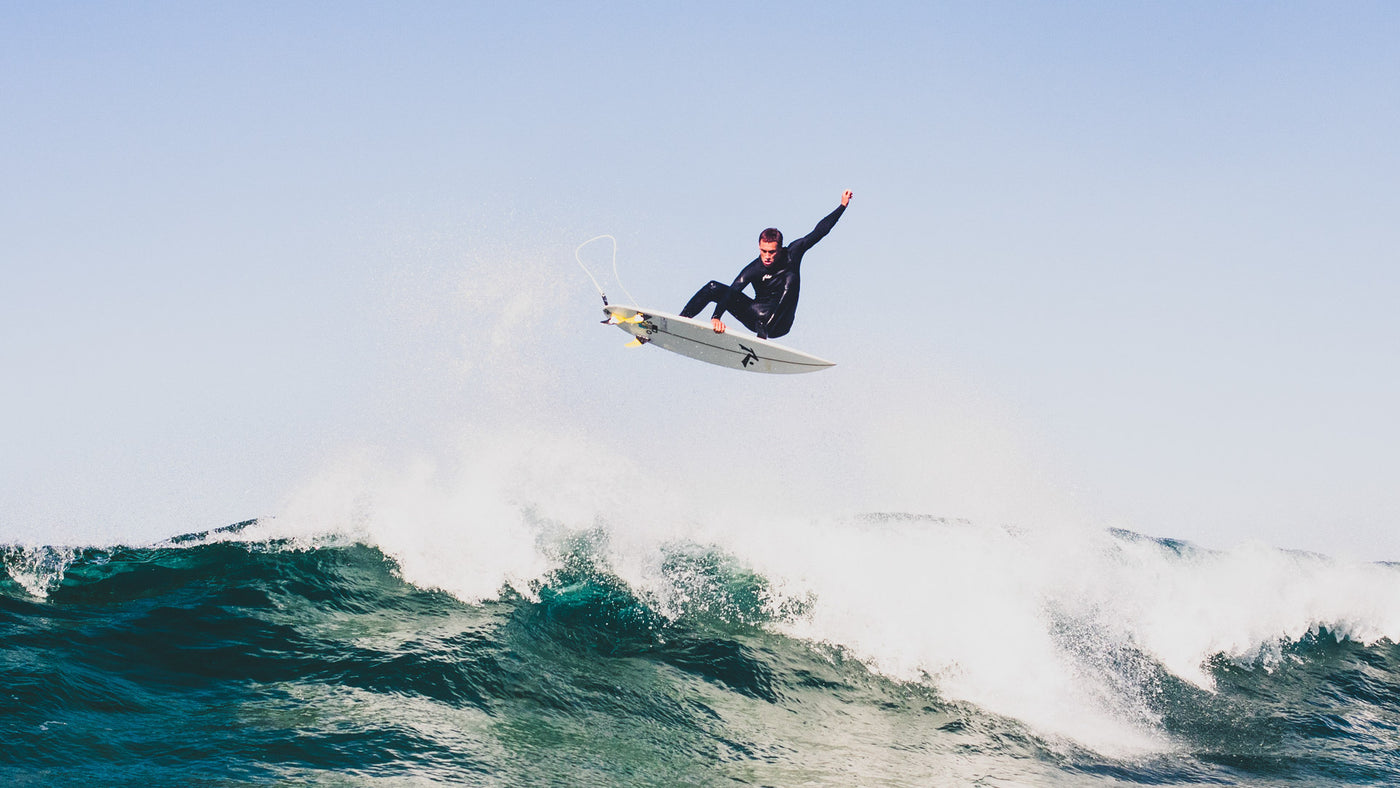 letty mortenson doing an air on a rusty surfboard